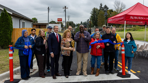 A group photo of the ribbon cutting for A Street Loop