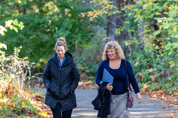 Two women walking a trail and smiling