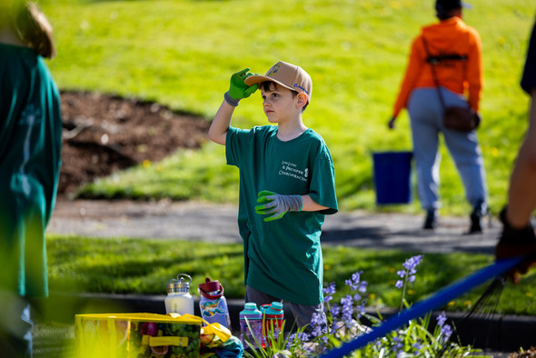 A kid standing in an Auburn park during clean sweep