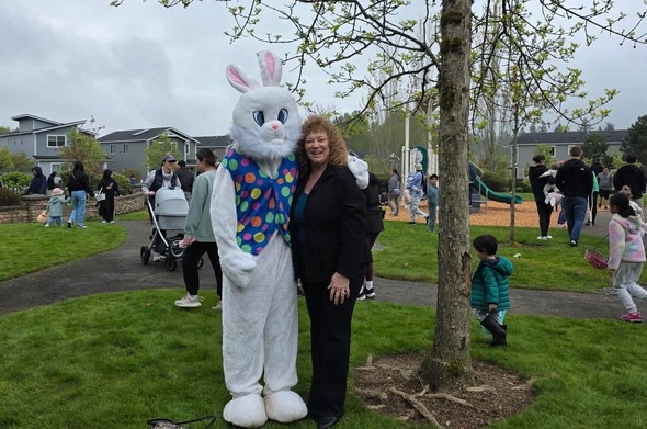 A woman standing next to a big ol easter bunny 