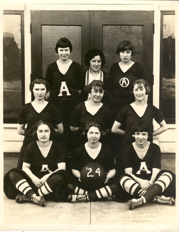 A vintage black-and-white photo of the 1924 Auburn High School girls’ basketball team, posed in uniform with a ball marked "'24."