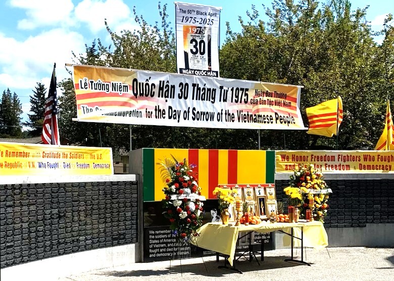 An altar adorned with flowers, flags, and offerings stands in front of banners.