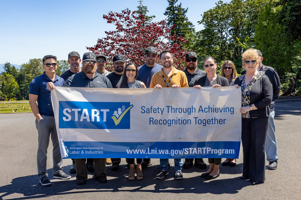 City of Auburn staff pose with a START banner after receiving safety recognition from the Washington State Department of Labor & Industries.