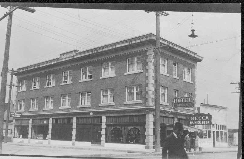 Historic black-and-white photo of the Hotel Green in Auburn, WA, showing early 20th-century architecture and street life with visible signage.