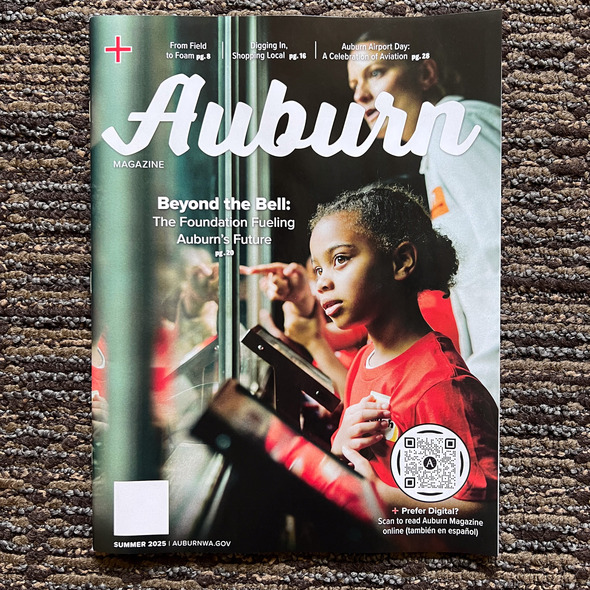A photo of the front cover of the Auburn Magazine showing a girl looking at an exhibit at a zoo
