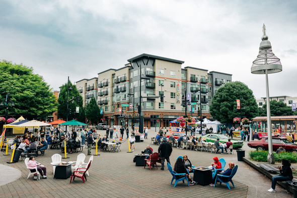 A wide view of Auburn’s downtown plaza bustling with people, fire pits, classic cars, and activity tents.