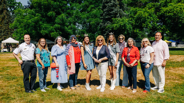 A group of people standing in a field smiling 