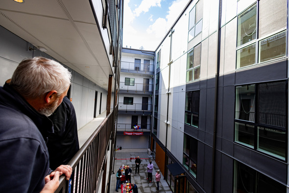 A man overlooking the railing at an indoor courtyard of an apartment building in Auburn Washington 