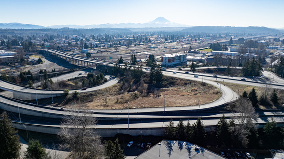 Aerial view of a freeway interchange in Auburn, WA, with Mount Rainier visible in the background.