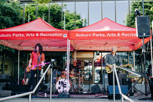 Band performing under Auburn Parks, Arts & Recreation tents.