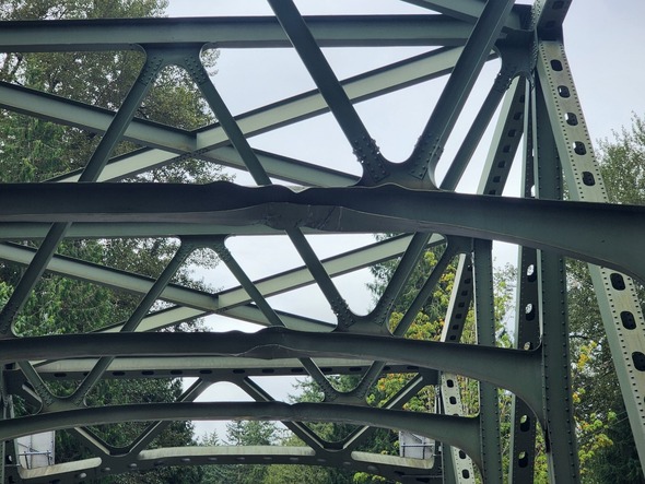 Close-up of bent beams on a steel truss bridge.