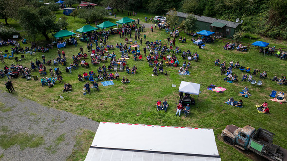 Aerial view of a crowd sitting on lawn chairs at an outdoor festival.