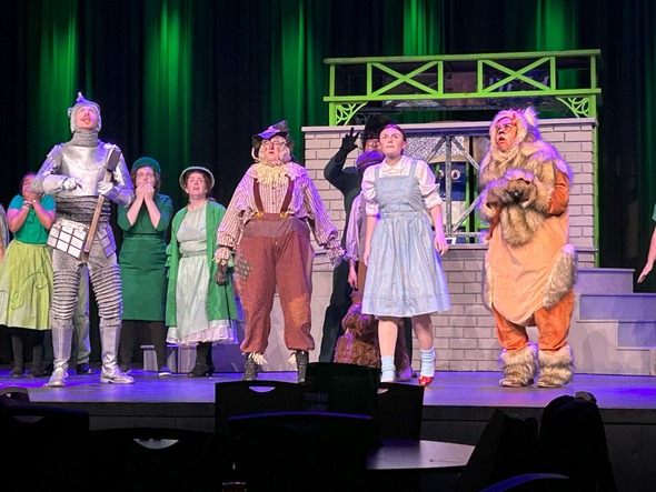 Auburn Community Players perform The Wizard of Oz on stage in colorful costumes.