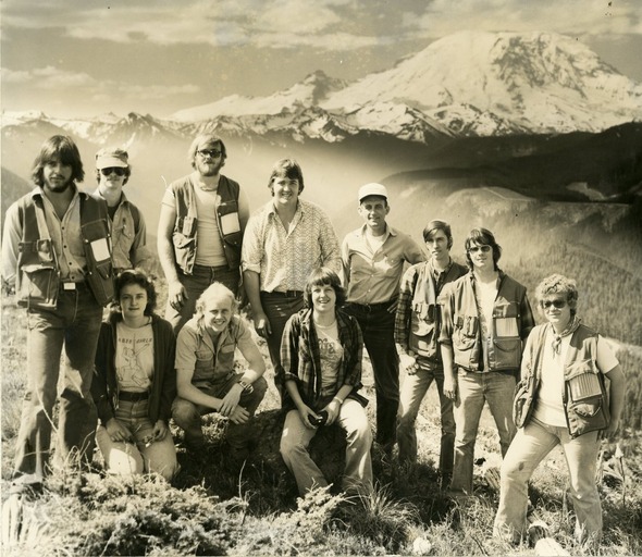 Group of people posing outdoors with Mount Rainier in the background.