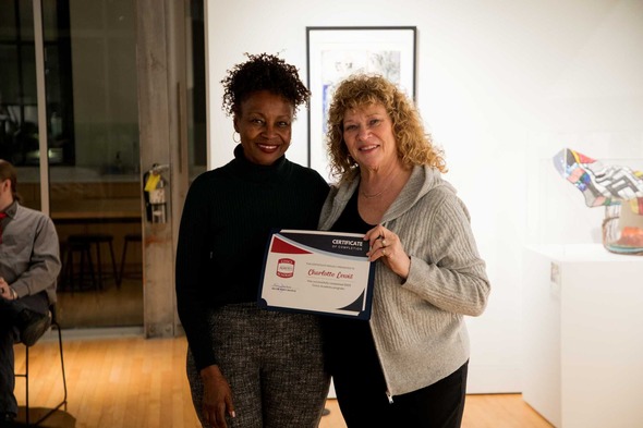 Mayor Nancy Backus presents a certificate to a Civics Academy graduate at a ceremony.