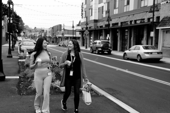Two women walking on a downtown road in Auburn, in black and white