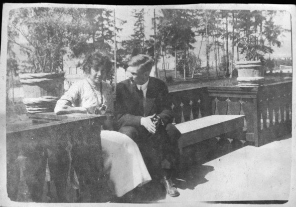 Grainy and black and white photo of a man and a woman sitting on a bench 