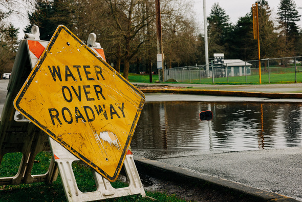 A yellow sign that says Water Over Roadway