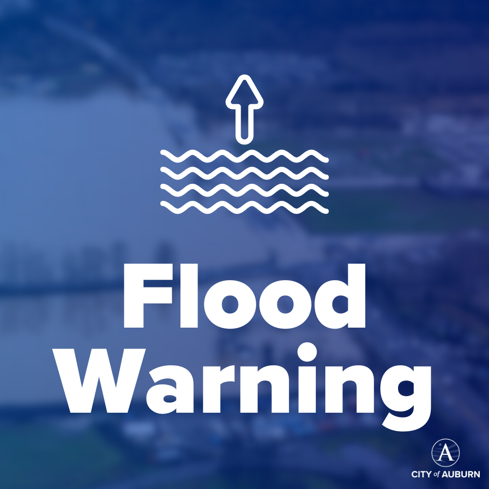 Graphic with rising water icon and text reading “Flood Warning” from the City of Auburn.