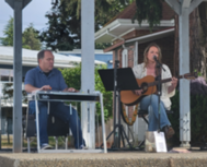 Two men on a stage playing guitar
