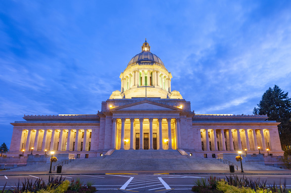 Washington State Capitol building illuminated at dusk under a blue evening sky.