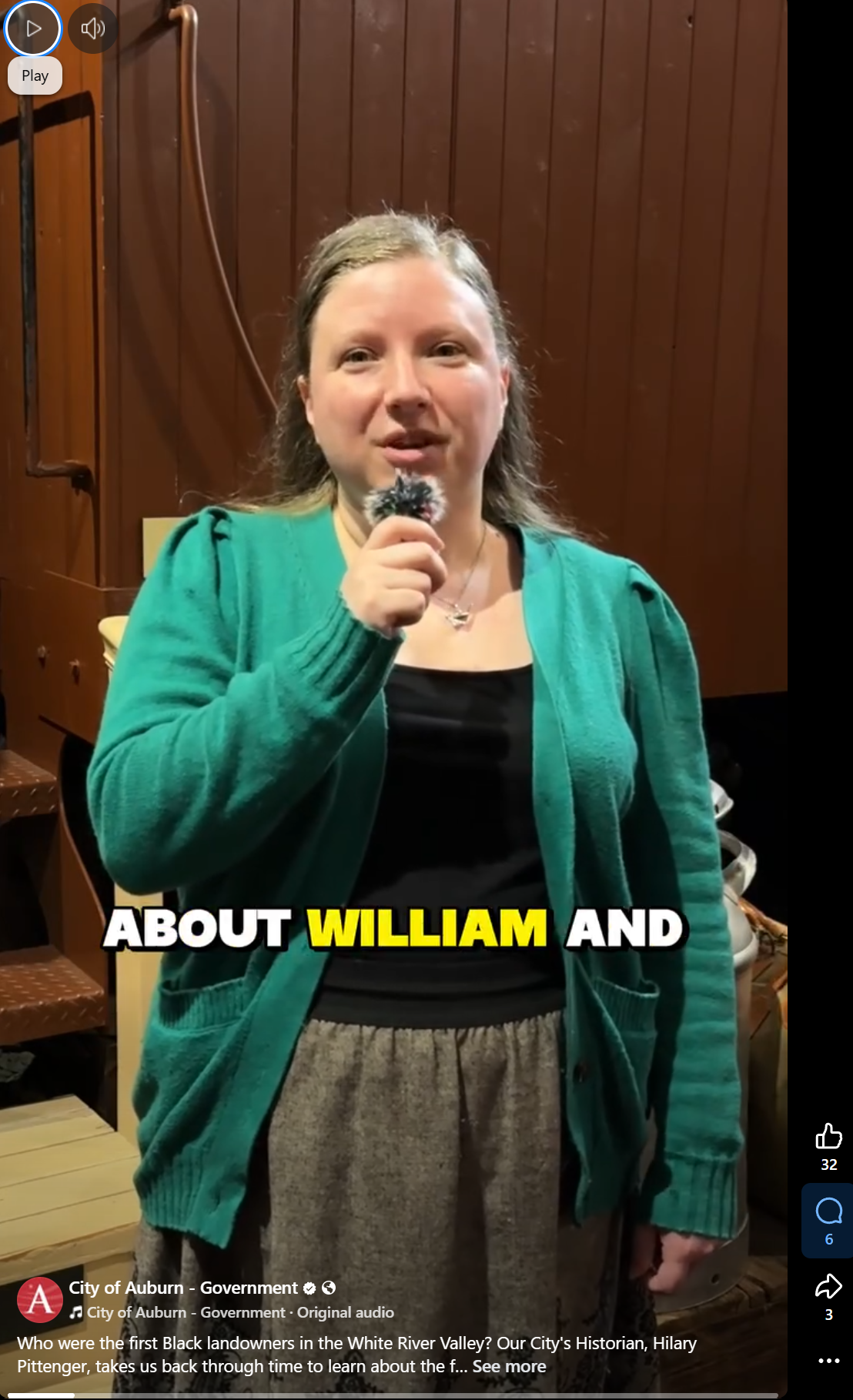 A screenshot of a Facebook video showing a woman holding a microphone standing in a museum 