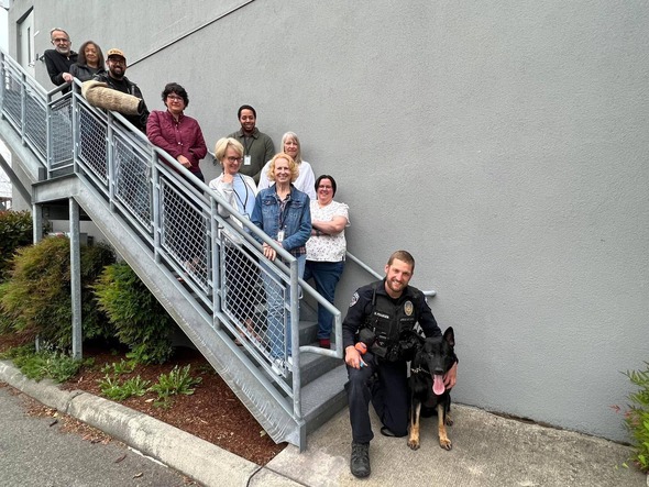 A handful of people standing on a stairwell facing the camera smiling 