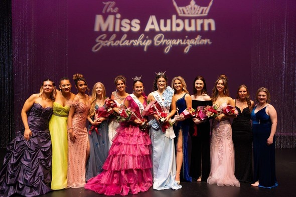 A bunch of women on stage with the words Miss Auburn's Scholarship Program above them 