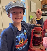 child in hat holding red lantern