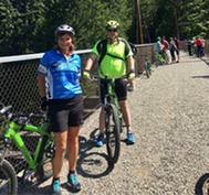 two adults standing beside bikes