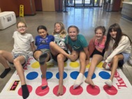 teens smiling for the camera while playing twister