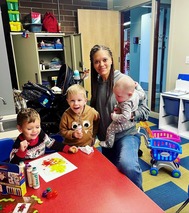 three children enjoying the childcare room with the supervisor
