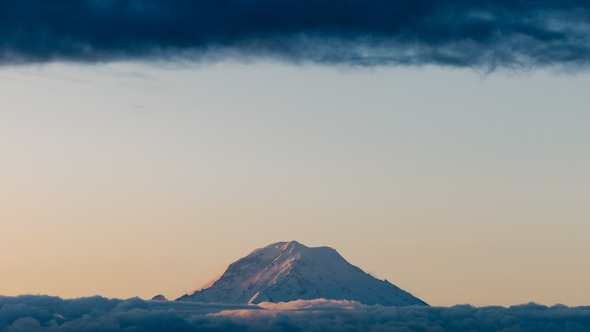 Mt. Rainier at sunrise flanked by clouds 
