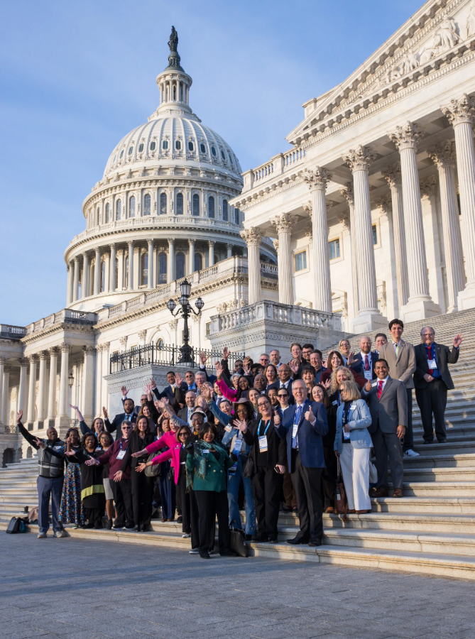 Large group of local leaders posing on the steps of the U.S. Capitol building in Washington, D.C.