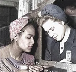 Historic photo of two women factory workers assembling equipment during wartime manufacturing.