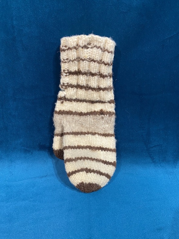 A single hand-knit sock with brown stripes displayed on a blue background.