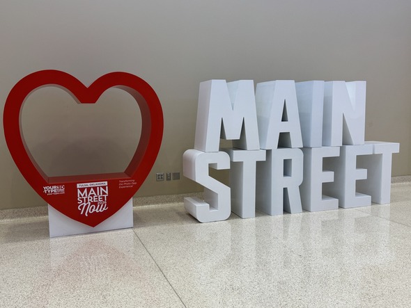 “Main Street” display with large white letters and red heart sculpture at Tulsa conference venue.