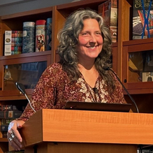 A smiling woman standing behind a podium