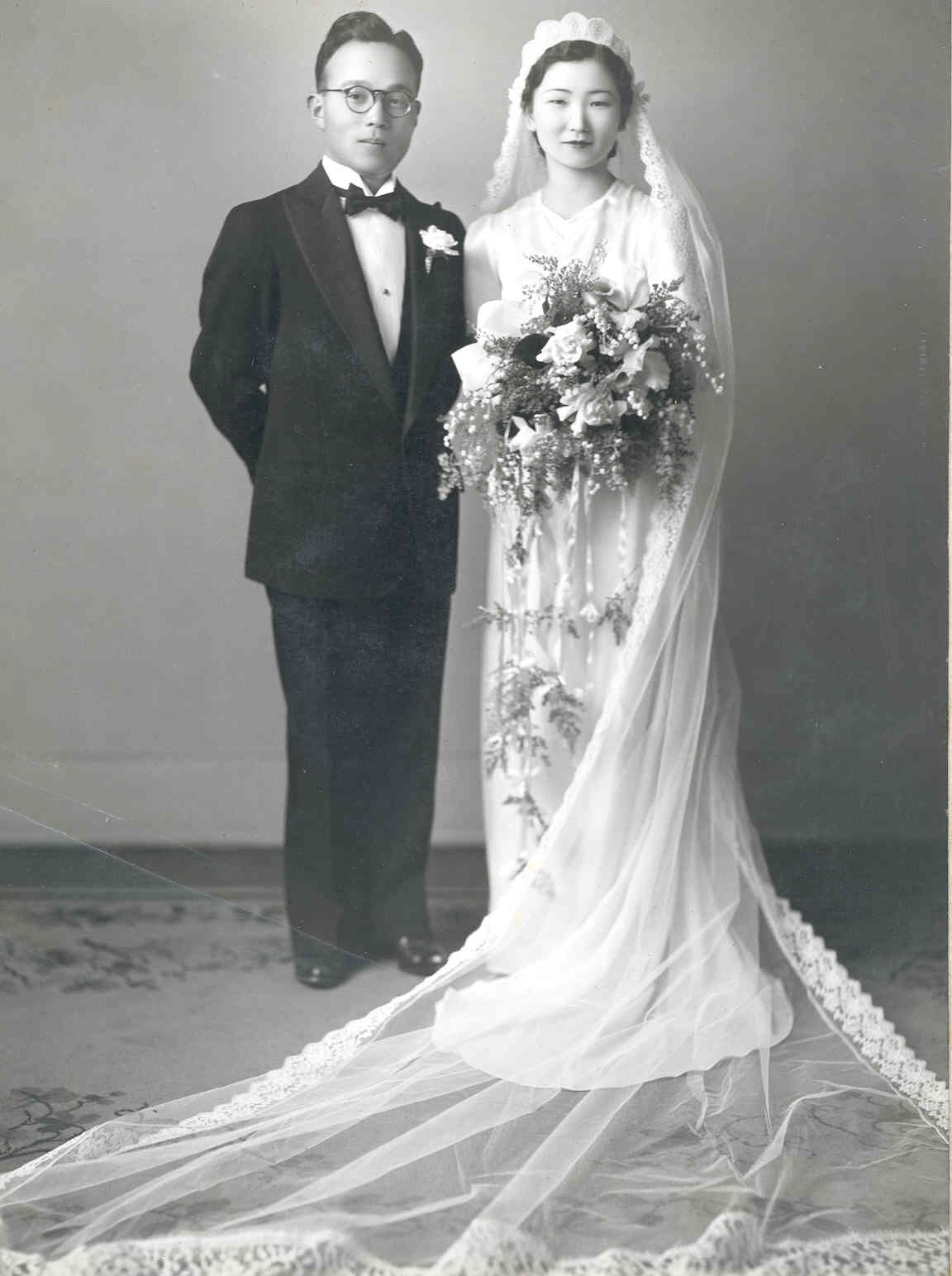 Black-and-white wedding portrait of a couple in formal attire.