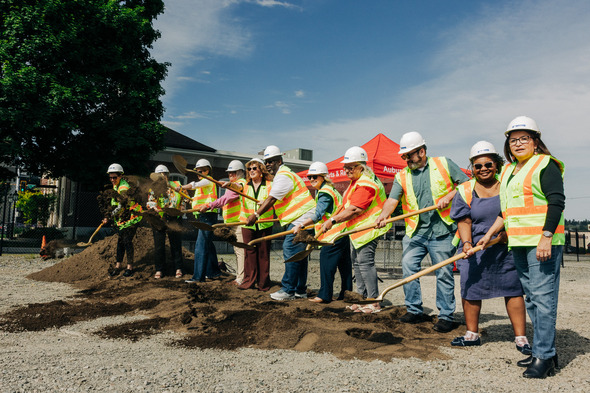City officials toss dirt with gold shovels during a groundbreaking ceremony.