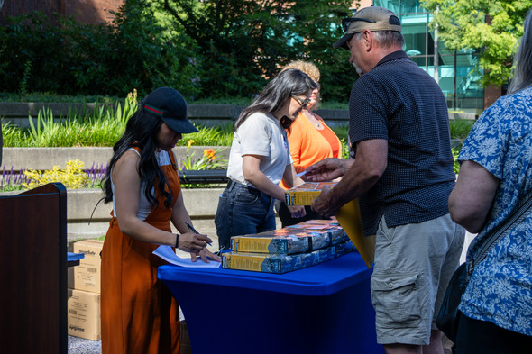 People hand out lockboxes at an outdoor table during an Auburn community safety event.