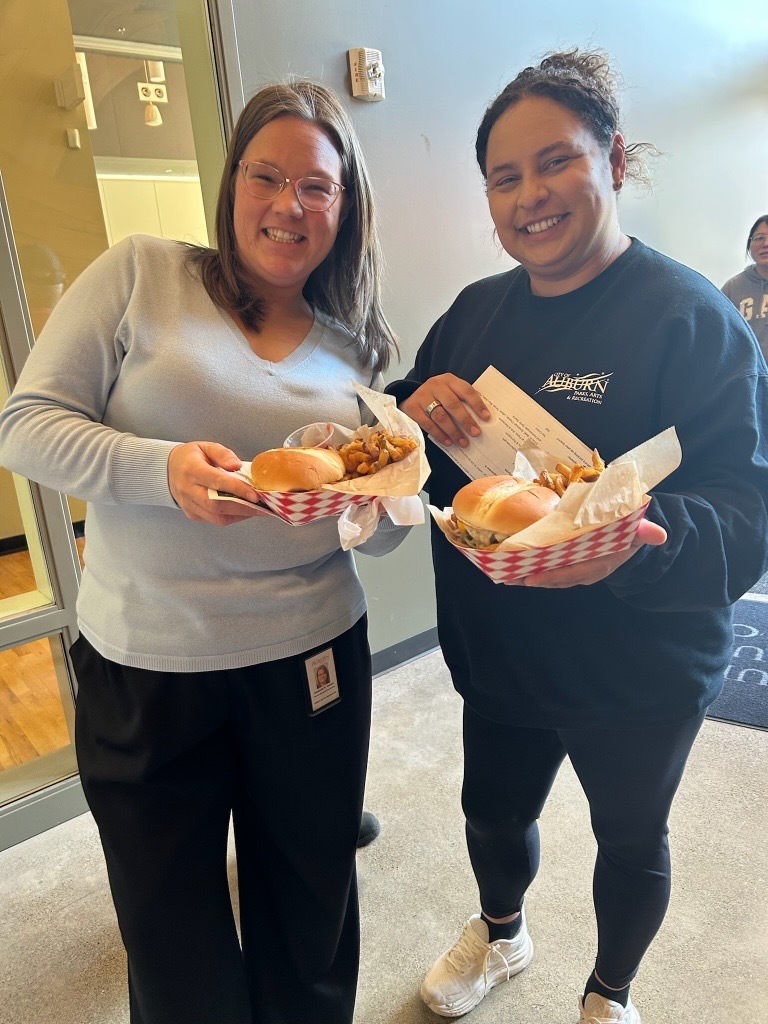 Two women holding food smiling 