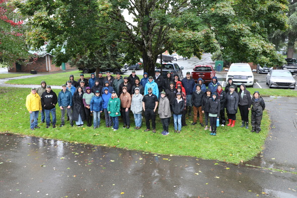 A group photo of people planting trees at Brannan Park in the rain 