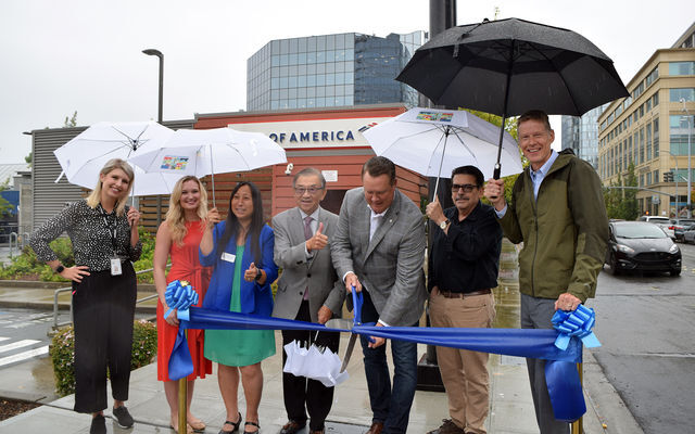 Photo of people with blue ribbon and large scissors