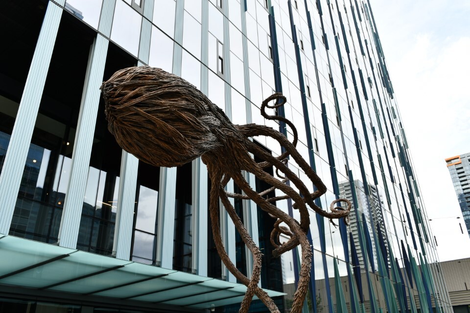 Image shows exterior art in the shape of an octopus in front of a building with 
