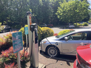 Image shows a vehicle plugged into an outdoor electric vehicle charging station