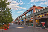 Image shows part of a shopping center with ground level retail shops and offices above.
