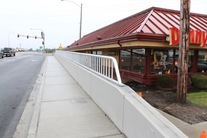 A new sidewalk and pedestrian wall with guardrail have been completed near Denny’s.