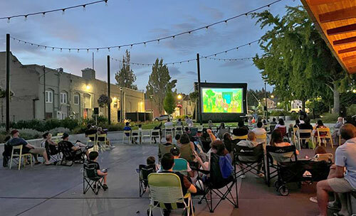 Families watch a movie on a temporary screen at Heritage Square