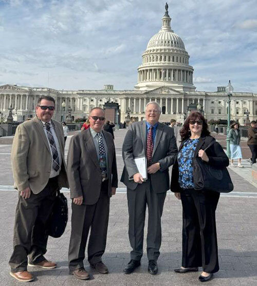 Pat Reay, Todd Kimball, Rick Eskil, and Elizabeth Chamberlain stand outside the U.S. Capitol in Washington, D.C.